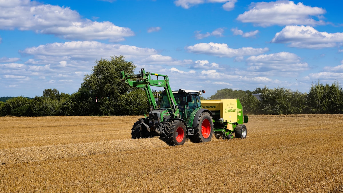 Traktor bei der Heuernte auf einem goldenen Feld